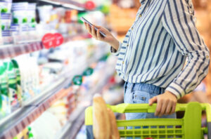 Woman uses her phone in a store equipped with a cell phone signal booster for retail.